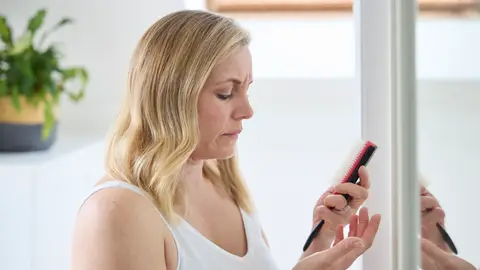 Mujer madura menopáusica que sufre pérdida de cabello Mujer madura menopáusica que sufre pérdida de cabello