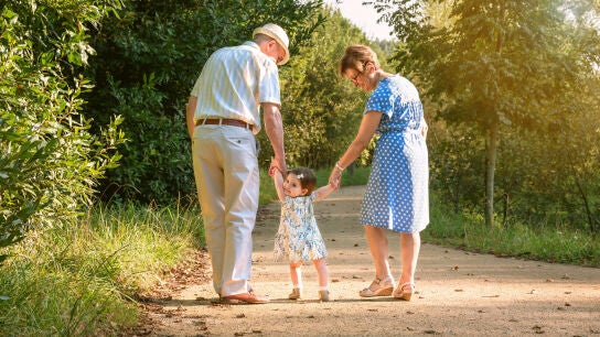 Unos abuelos dando un paseo con su nieta