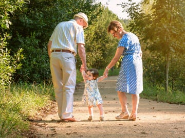 Unos abuelos dando un paseo con su nieta