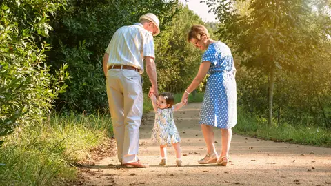 Unos abuelos dando un paseo con su nieta Unos abuelos dando un paseo con su nieta