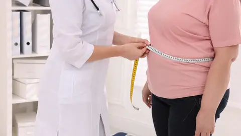 Doctora midiendo la cintura de una mujer Doctora midiendo la cintura de una mujer