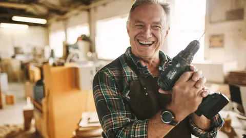 Hombre mayor trabajando con un taladro Hombre mayor trabajando con un taladro
