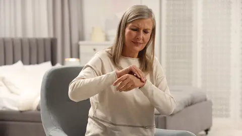 Mujer con dolor en las articulaciones de las manos Mujer con dolor en las articulaciones de las manos