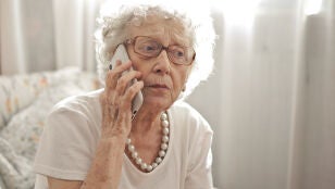 Mujer preocupada llamando por tel&eacute;fono