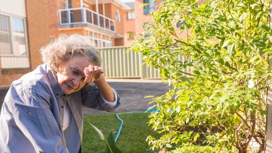 Mujer mayor practicando jardiner&iacute;a y con calor