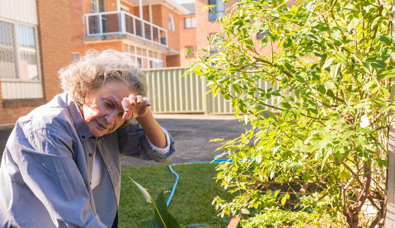 Mujer mayor practicando jardiner&iacute;a y con calor