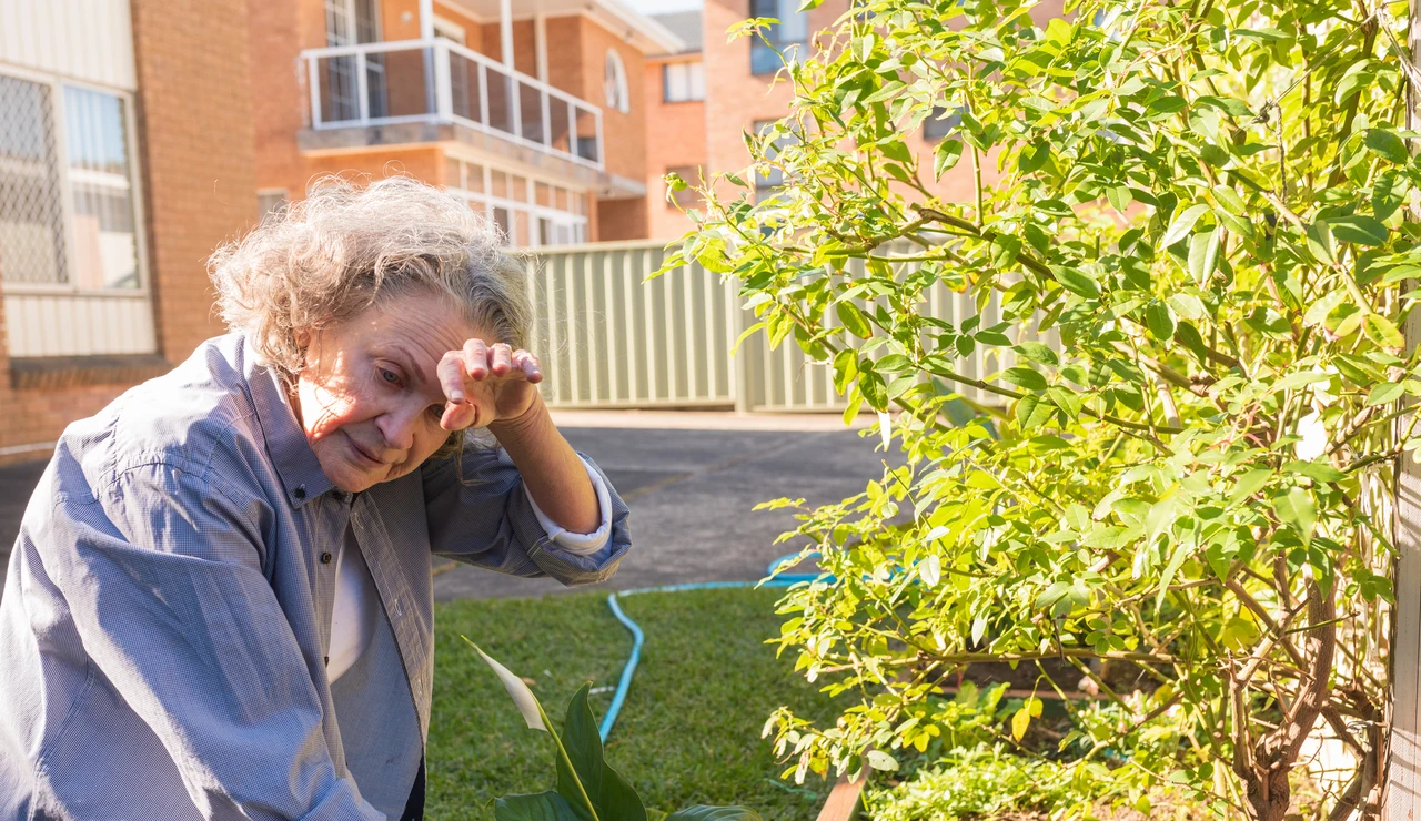 Mujer mayor practicando jardinería y con calor