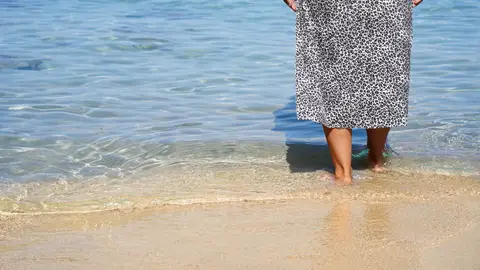Mujer mayor caminando por la playa Mujer mayor caminando por la playa