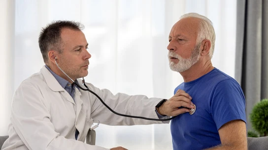 Médico auscultando el corazón a un hombre mayor Médico auscultando el corazón a un hombre mayor