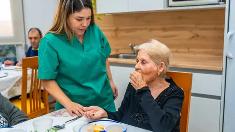 Mujer en el comedor de una residencia tomando pastillas Mujer en el comedor de una residencia tomando pastillas
