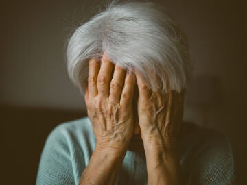 Mujer mayor con las manos en cara