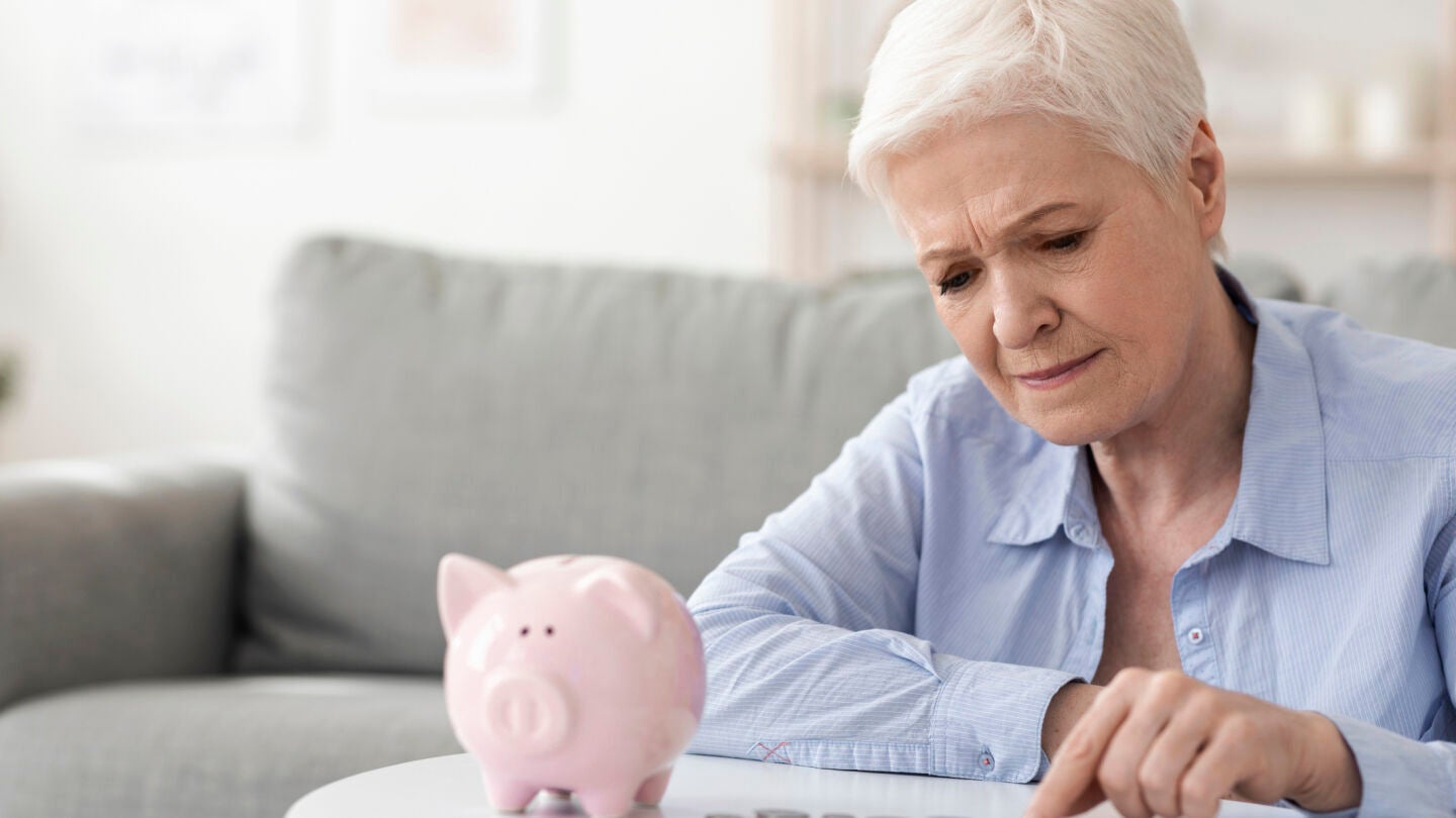 Mujer mayor contando dinero de una hucha