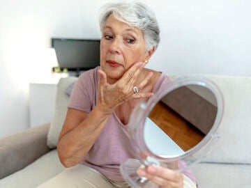 Mujer mayor mir&aacute;ndose en un espejo