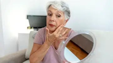 Mujer mayor mirándose en un espejo Mujer mayor mirándose en un espejo