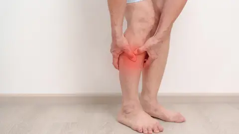 Mujer mayor con dolor en la pantorrilla Mujer mayor con dolor en la pantorrilla