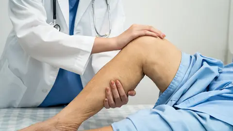 Doctor examinando los músculos de una pierna Doctor examinando los músculos de una pierna