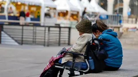 Una cuidadora permanece sentada con la mujer mayor a la que asiste Una cuidadora permanece sentada con la mujer mayor a la que asiste