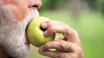 Hombre mayor comiéndose una manzana Hombre mayor comiéndose una manzana