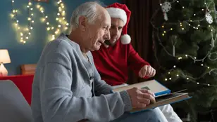 Hombre mayor con demencia viendo un álbum de fotos