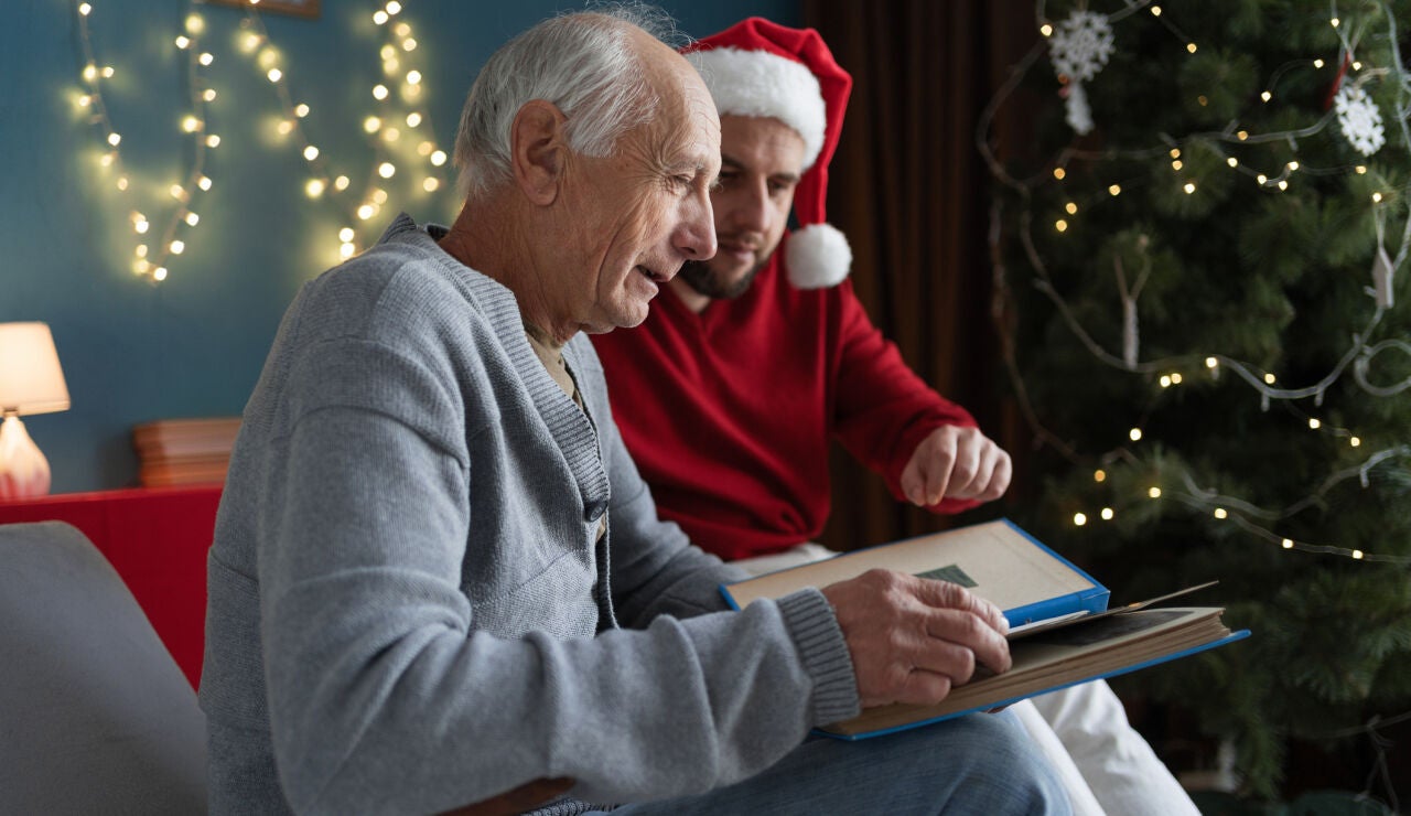 Hombre mayor con demencia viendo un &aacute;lbum de fotos