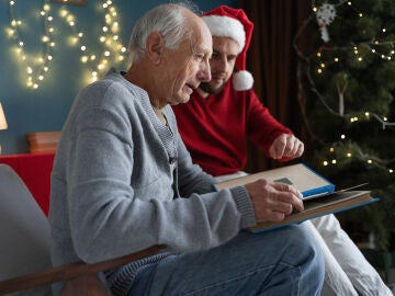 Hombre mayor con demencia viendo un &aacute;lbum de fotos