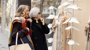 Dos mujeres mirando el escaparate de una tienda de ropa Dos mujeres mirando el escaparate de una tienda de ropa