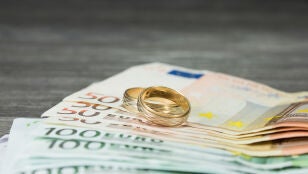 Anillos de boda sobre dinero en efectivo