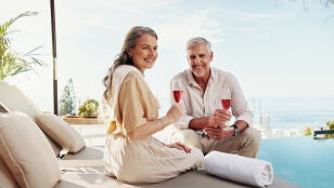 Pareja mayor disfrutando de una copa en una piscina