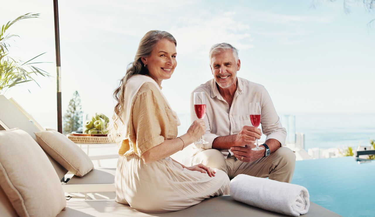 Pareja mayor disfrutando de una copa en una piscina