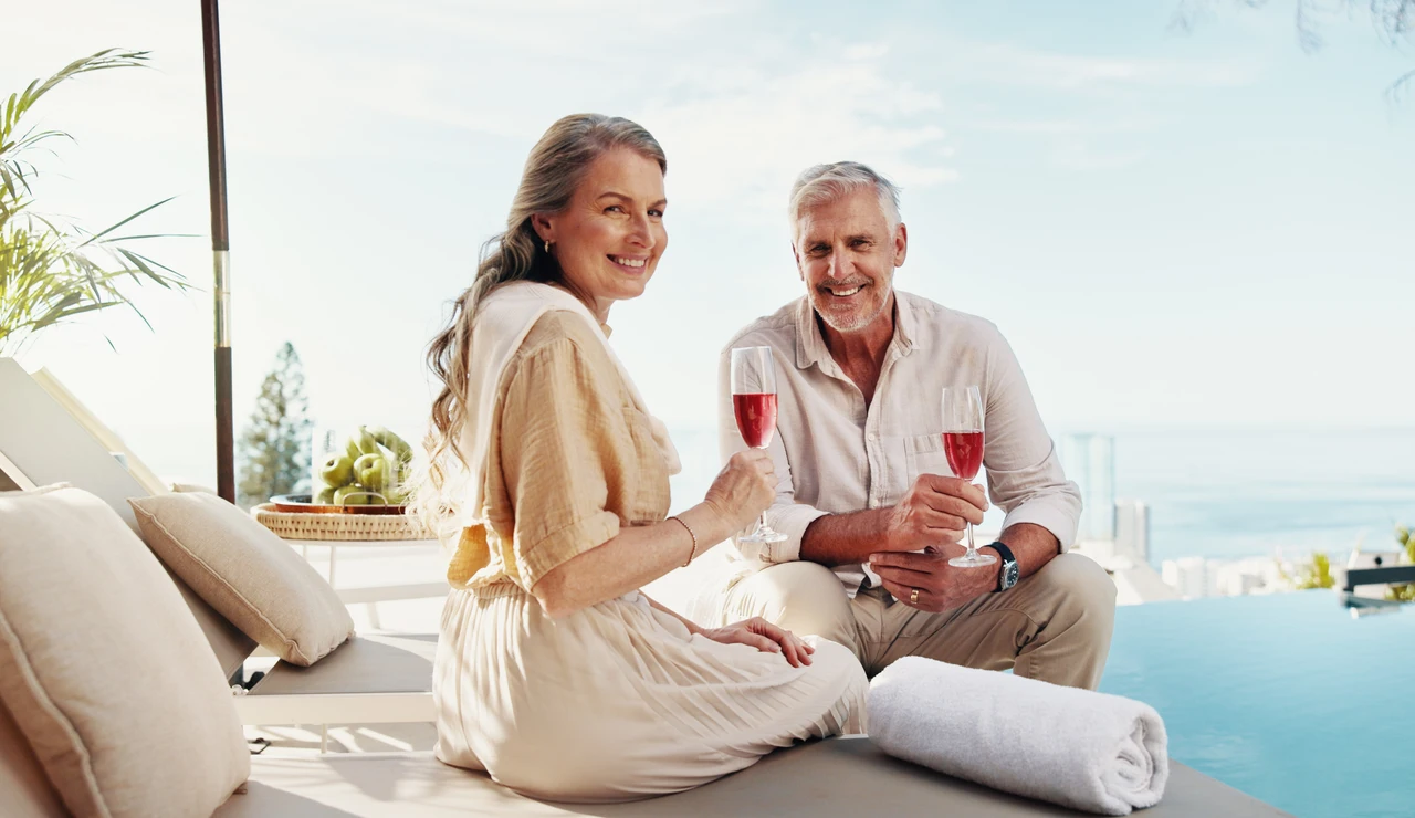 Pareja mayor disfrutando de una copa en una piscina