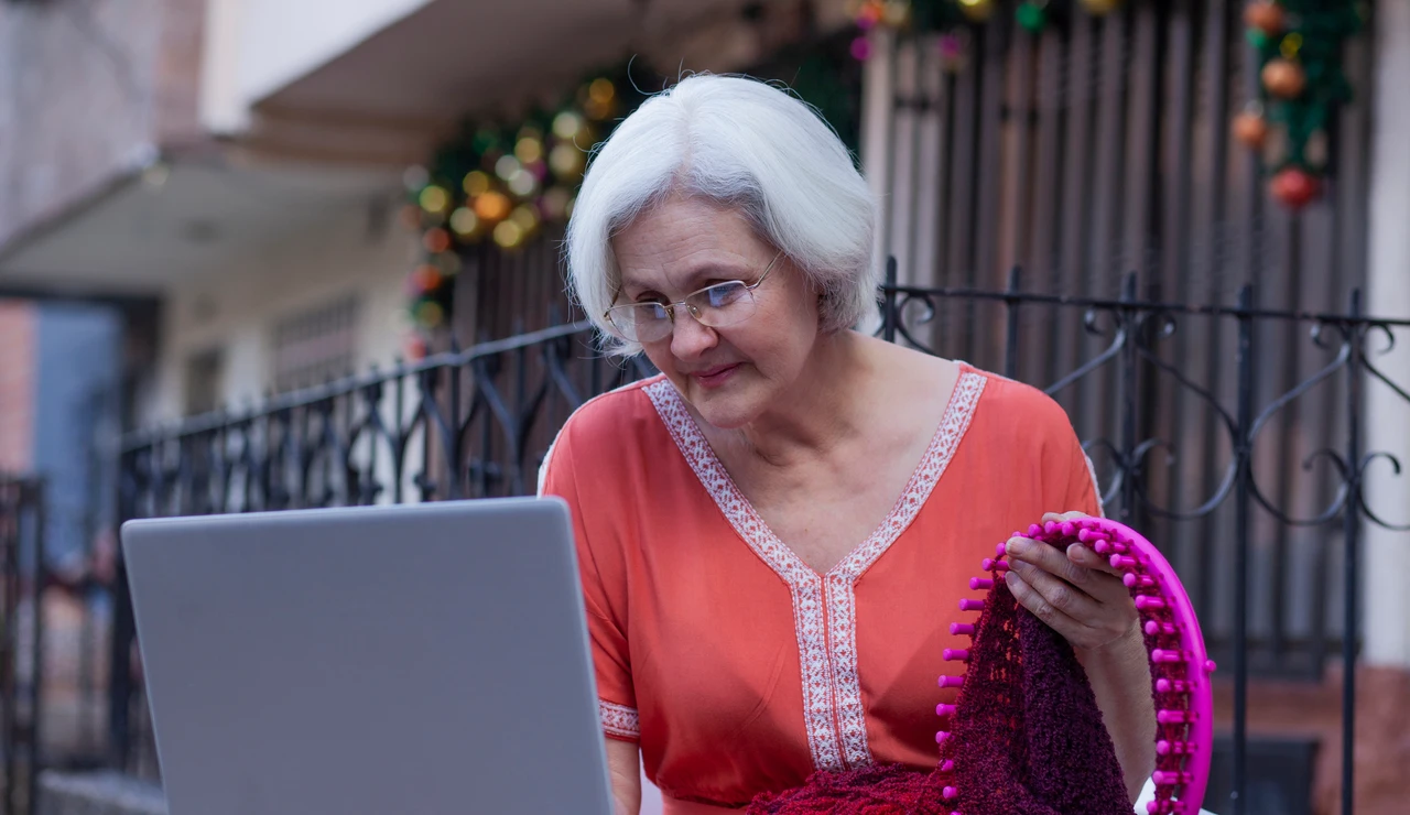 Mujer mayor consultando un tutorial en un ordenador