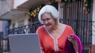 Mujer mayor consultando un tutorial en un ordenador