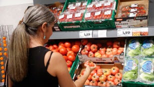 Una mujer comprueba la calidad de los tomates en un establecimiento