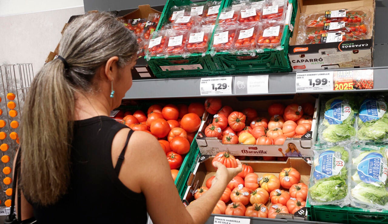 Una mujer comprueba la calidad de los tomates en un establecimiento