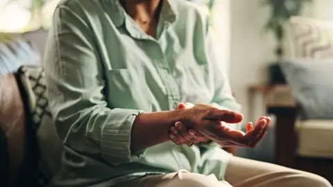 Mujer mayor con artrosis en la muñeca Mujer mayor con artrosis en la muñeca