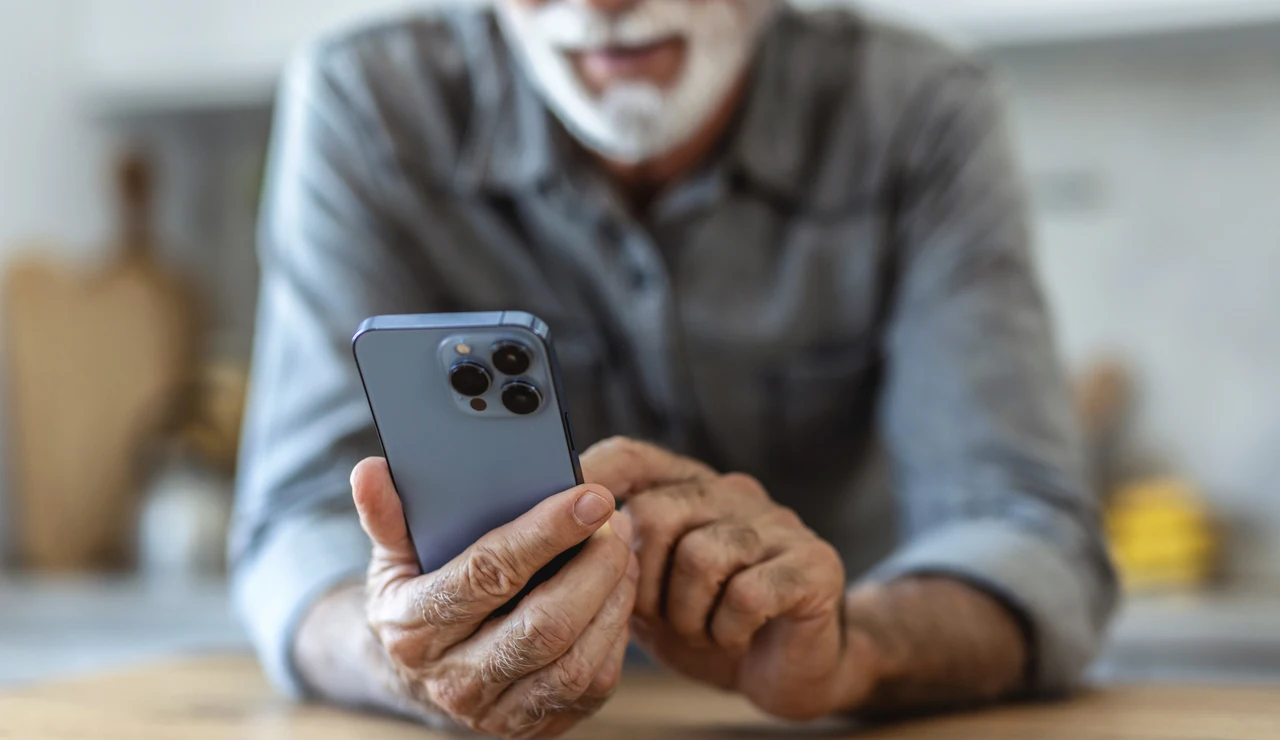 Hombre mayor consultando un teléfono móvil