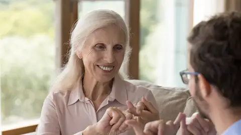 Dos personas conversan en lenguaje de signos Dos personas conversan en lenguaje de signos