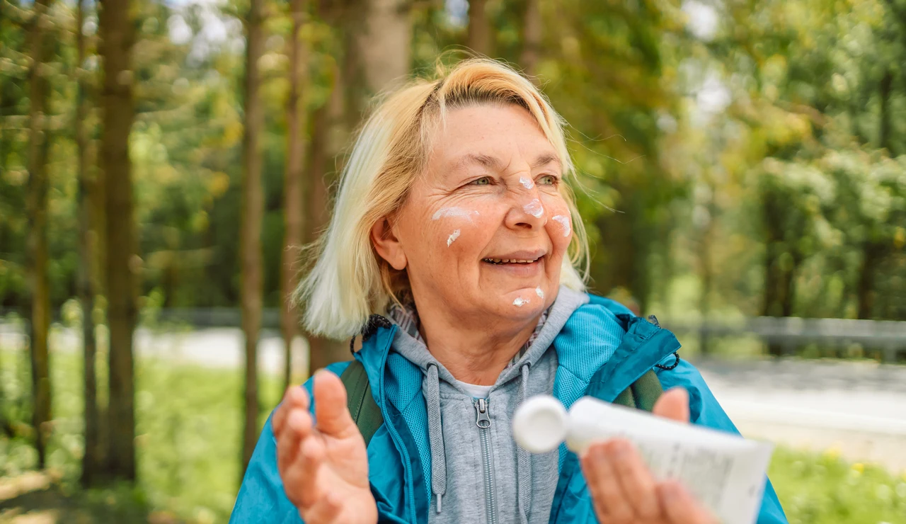 Mujer mayor aplicándose crema solar