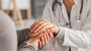 Mujer mayor d&aacute;ndose las manos con una doctora