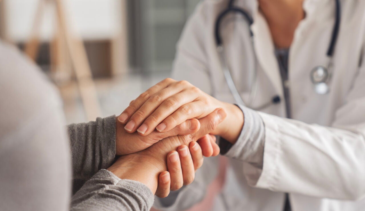 Mujer mayor d&aacute;ndose las manos con una doctora