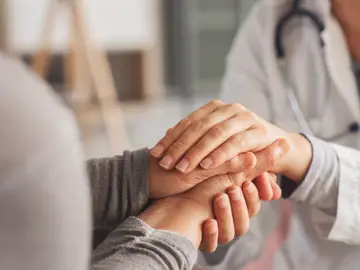 Mujer mayor dándose las manos con una doctora Mujer mayor dándose las manos con una doctora