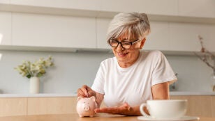 Mujer poniendo dinero en una hucha