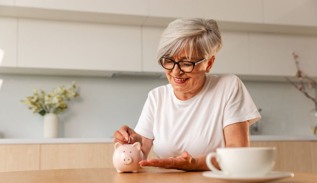 Mujer poniendo dinero en una hucha