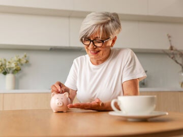 Mujer poniendo dinero en una hucha