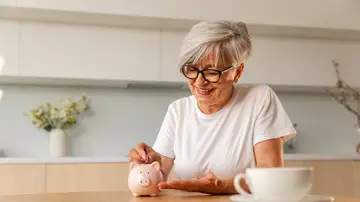 Mujer poniendo dinero en una hucha Mujer poniendo dinero en una hucha
