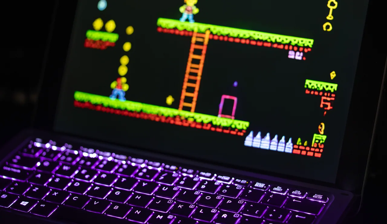 Primer plano de un portátil que muestra un videojuego retro con un teclado iluminado con luces de neón, capturando la experiencia nostálgica del juego