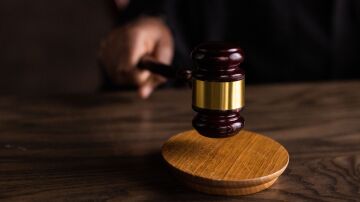 Una vista en primer plano de un mazo de juez sobre un escritorio, simbolizando la justicia y la ley.