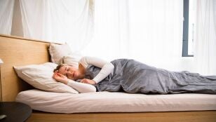 Mujer descansando sobre una cama