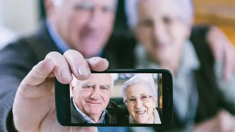 Dos personas mayores muestran una imagen tomada con su móvil. Dos personas mayores muestran una imagen tomada con su móvil.