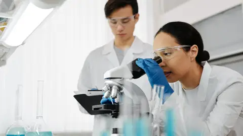 Este es el ‘Top ten’ de las personas más influyentes para la ciencia en 2022 para la revista ‘Nature’ Mujer mira al microscopio